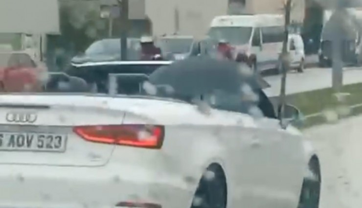 Bursa'da ilginç görüntüler: Milyonluk arabada ıslanmamak için şemsiye açtı